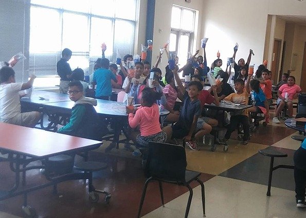 Kids in classroom celebrating during dental presentation in Dallas
