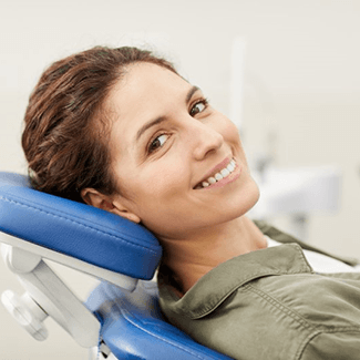 a patient smiling after receiving dental crowns