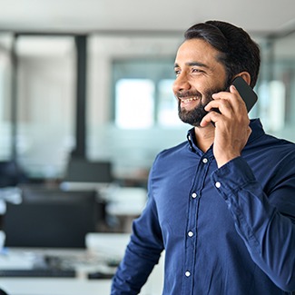 Man wearing blue button-down shirt on the phone