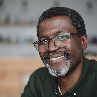 Man with glasses showing off new smile