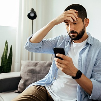 worried man holding cellphone