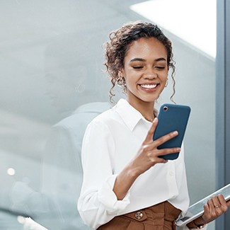 a person smiling and looking at their phone