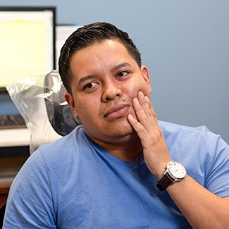 dental emergency patient holding mouth in pain