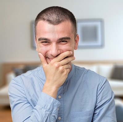 Man covering his smile with his hand