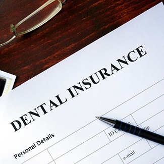 a dental insurance claim form with an X-ray behind it