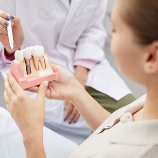 Dental patient learning about how dental implants in Dallas work