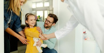 Child shaking hands with her family dentist