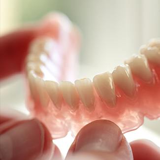 Hands holding a full denture