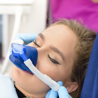 Young woman wearing nitrous oxide mask over her face