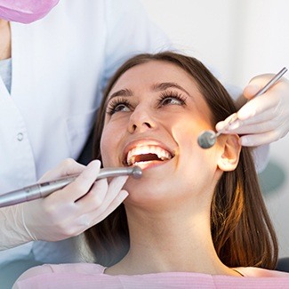 Woman in dental chair receiving restorative dentistry treatment in Dallas