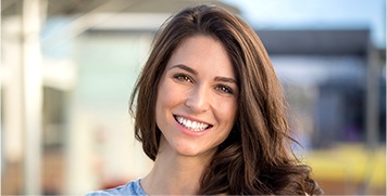 Young brunette woman smiling outdoors