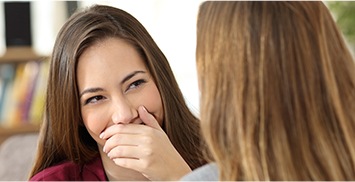 Woman covering her smile with her hand