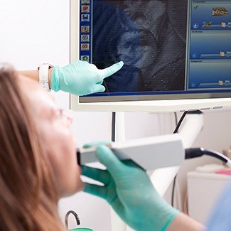 Dallas dentist showing intraoral camera photos on computer screen