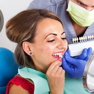 A woman reviewing porcelain veneers with a dentist.