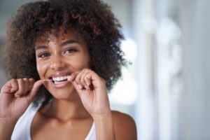 Woman flossing teeth.